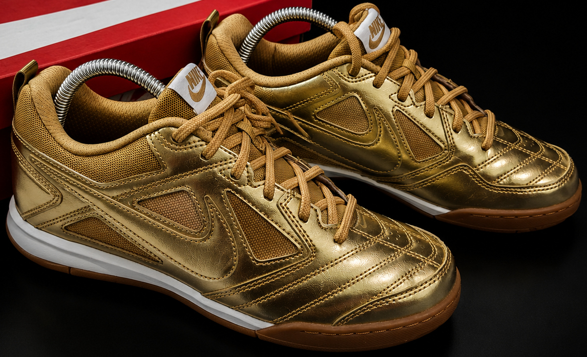 Gros plan Nike Gato LV8 GS Metallic Gold swoosh rouge et tige brillante