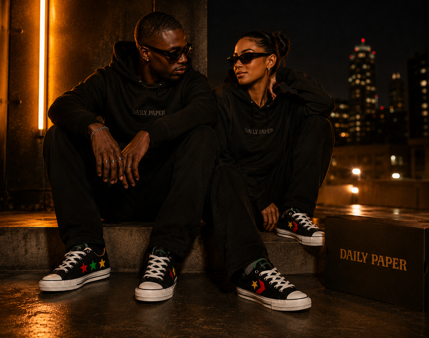 Daily Paper x Converse All Star portée par un couple en tenue urbaine de nuit sur fond premium cuivre