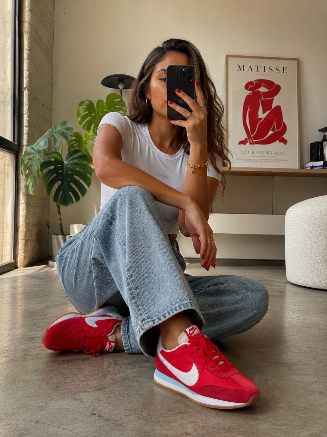 Femme portant les Nike Pacific HM4771-604 rouges dans un intérieur lifestyle moderne et lumineux