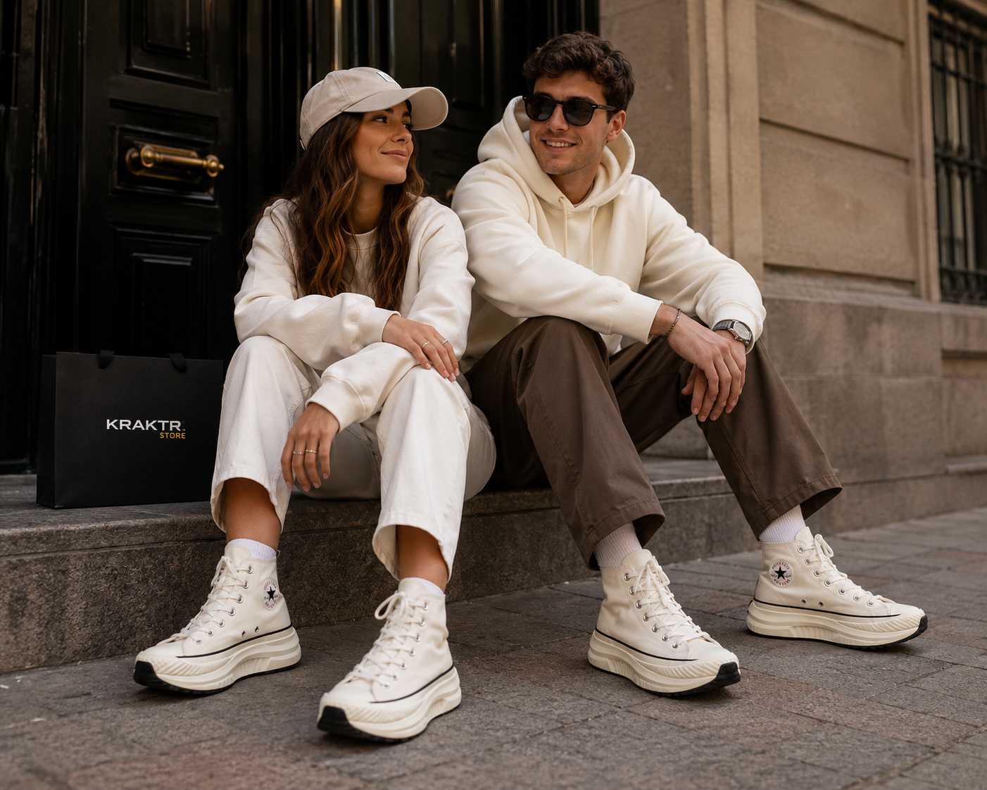 Couple portant les Converse Chuck 70 AT-CX Hi Vintage White Egret Black dans un décor urbain premium avec sac KRAKTR STORE et style streetwear minimaliste.